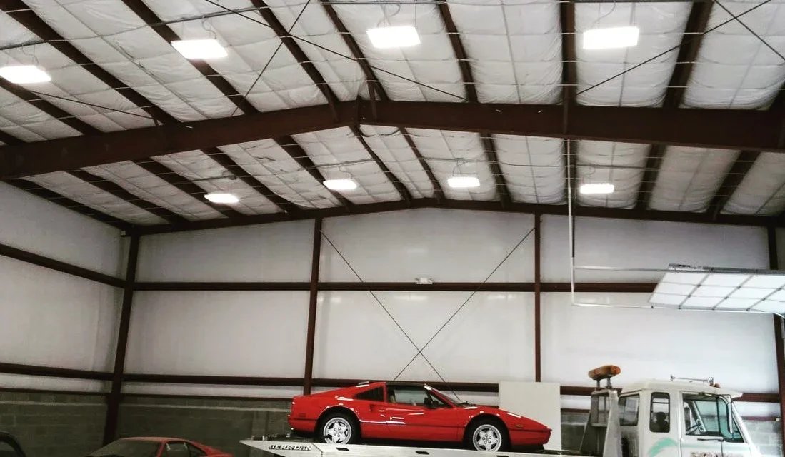 Exposed steel-frame commercial garage interior with high-bay lighting and branch power